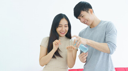 Asian family are using alcohol gel to wash their hands thoroughly to prevent dirt. And the spread of COVID-19. Couple are happy to live together in a healthy relationship. Concept Health care