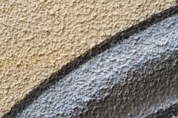 Rissige Betonwand beige grau schwarz