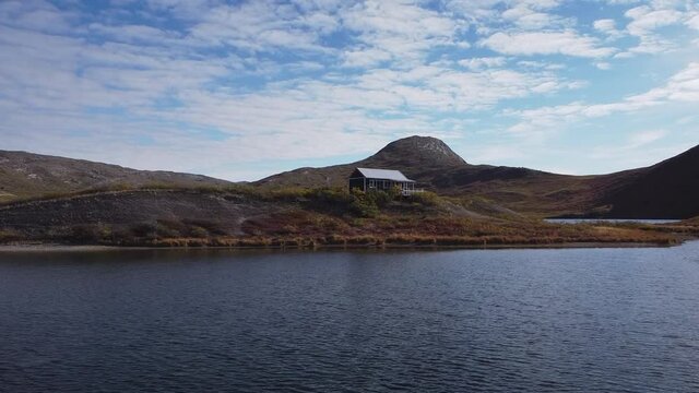 Summer house on a small peninsula with The Sugarloaf mountain in background. Near Kangerlussuaq Airport, Greenland.