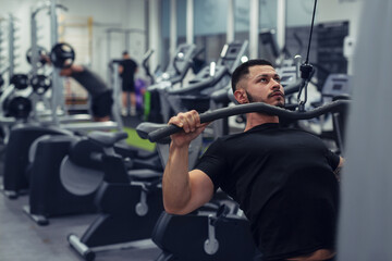 Fototapeta na wymiar Bodybuilder working out in gym with determination