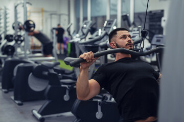 Bodybuilder working out in gym with determination