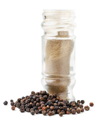 Black pepper and ground pepper in a glass bottle on a white background. Isolated