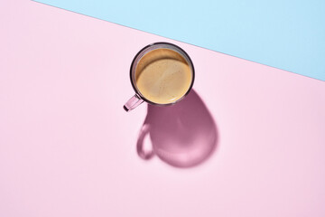 Fresh one cup espresso coffee on pastel pink with deep shadows. Food background. Top view. Minimalism.