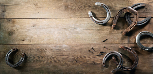 Old rusty horse shoes on barn floor - obrazy, fototapety, plakaty