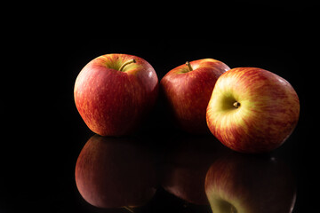 Apples, beautiful red apples on reflective surface, black background, selective focus.