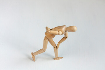 a bent wooden mannequin suffering from backache