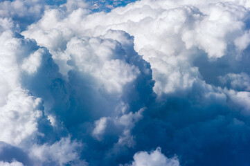 Naklejka na ściany i meble Cumuluswolken am blauen Himmel vom Flugzeugfenster aus gesehen
