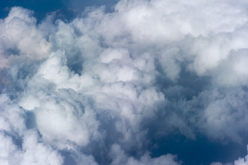 Cumuluswolken am blauen Himmel vom Flugzeugfenster aus gesehen