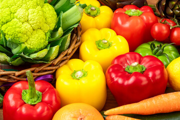 Yellow and red peppers with cauliflower on a brown wooden table