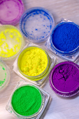 Jars of dry multi-colored pigments in a nail salon for nail design.