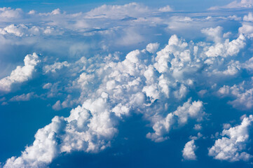 Cumuluswolken am blauen Himmel vom Flugzeugfenster aus gesehen