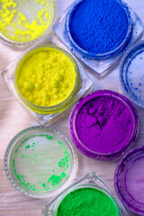 Jars of dry multi-colored pigments in a nail salon for nail design.
