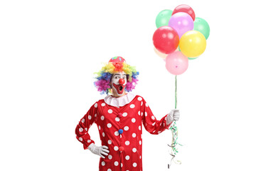 Surprised clown holding a bunch of balloons
