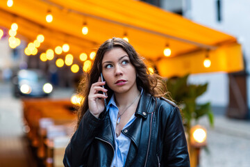 portrait of a cute and gorgeous women posing on blurred strret background with bokeh light