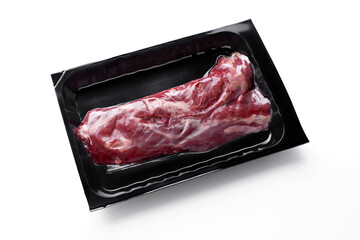 Raw beef steak in vacuum black package isolated on white background-image. Vacuum packaging mockup.