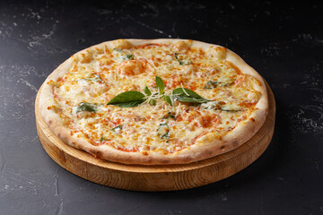 Pizza 4 cheeses on a dark concrete background.