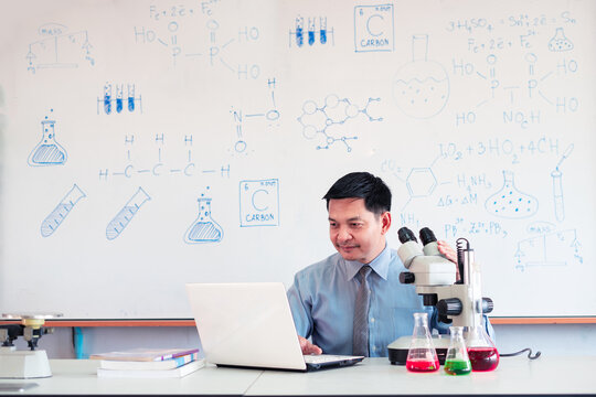 Science Chemistry Teacher Teaching Online With Microscope And Laptop In The Classroom