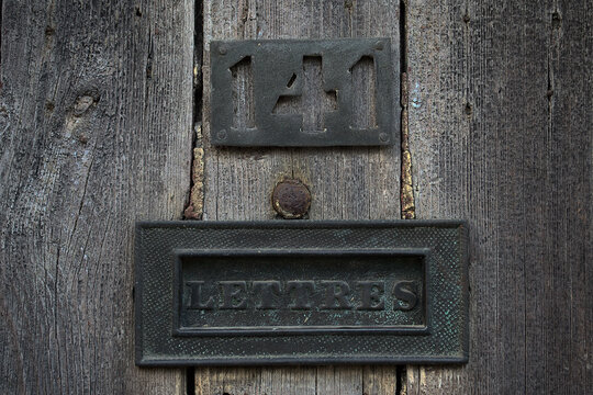 Close up of a mailslot on an old door in france