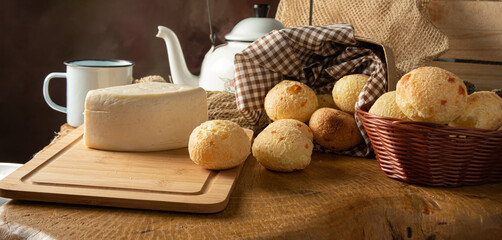 Cheese bread, Brazilian breakfast arrangement, cheese bread, white cheese, kettle and accessories, dark abstract background, selective focus..