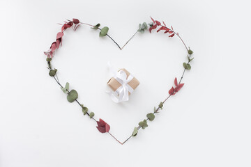 Small gift bag inside a heart shape made of flowers