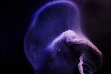 Abstract purple smoke moves on black background. Beautiful swirling smoke.