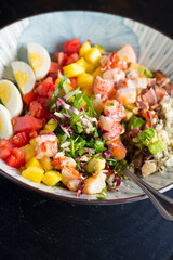 Cobb salad. Classic American restaurant or French bistro Cobb salad, made with chopped Bibb or Romain lettuce, heirloom tomatoes, bacon, blue cheese, avocado, hard boiled eggs tossed with olive oil.