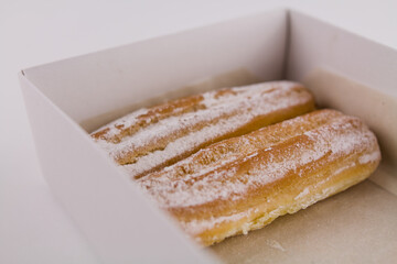 delicious French eclairs in a box with powdered sugar