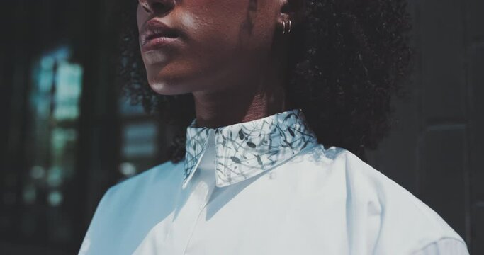 Close up of a young african woman wearing a white shirt and earrings