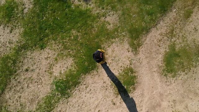 Aerial zoom shot of dark-haired man in a garden. drone image.