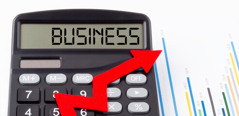 Obraz premium Calculator with red ascending arrow and text Business on the display,concept
