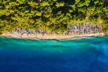 Fototapeta na wymiar Mediterranean sea. Aerial view on beach and people. Vacation and relax. Beach and blue water. Top view from drone at beach and azure sea. Travel and holiday