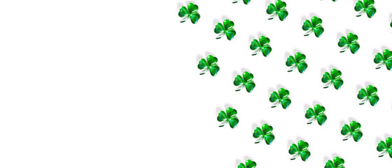 Banner with pattern Shamrock symbols made of green decorative glass hearts lying on white background and copy space. Happy St. Patrick's Day Irish holiday. Spring 17 march lucky clover design