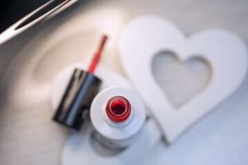 Beautiful red varnish in a bottle in a nail salon for nail design for Valentine's Day.