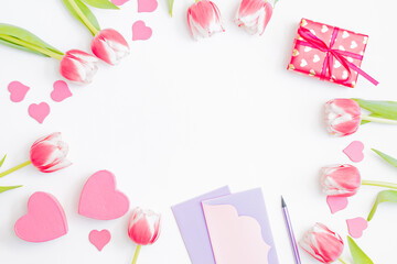 Flat lay valentines day frame with pink tulips and gift box on a white background