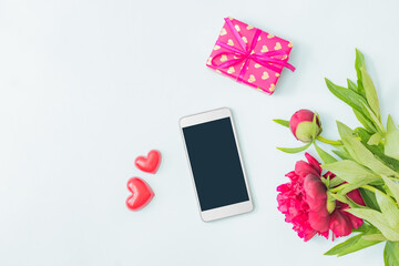 Flat lay mockup smartphone blank screen with red peonies and gift box on a light background