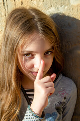 Naklejka premium girl teenager puts her finger to her nose, as if keeping something secret