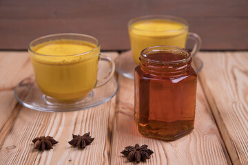 Cups of golden milk on a wooden background. Golden milk helps to relieve stress and depression, normalizes the work of the intestines.