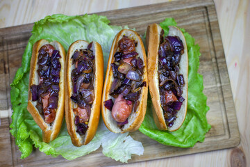 hot dogs with fried onions on lettuce leaves