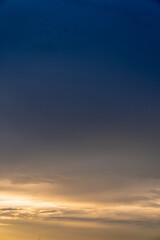 Calm dark sunset sky. Yellow and blue colours. Vertical photo