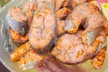 Grilled red fish trout steaks lie on a glass plate