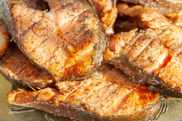 Grilled red fish trout steaks lie on a glass plate