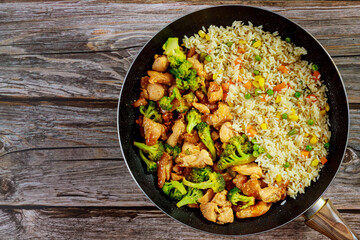 Obraz na płótnie Canvas Stir-fry chicken with broccoli in sweet and sour sauce and rice.