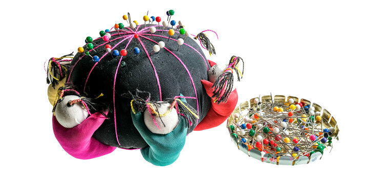 A Pin Cushion And Selection Of Pins Isolated On A Plain White Background