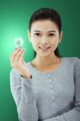 Oriental fashion young female holding a light bulb