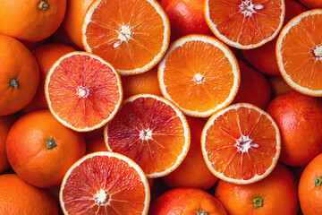 Many blood oranges, whole and halved