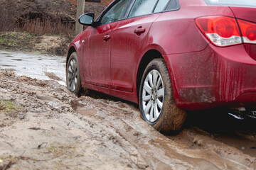 Car stuck in the mud, car wheel in dirty puddle, rough terrain