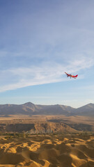 The plane over the desert . Passenger aircraft over mountain landscape.