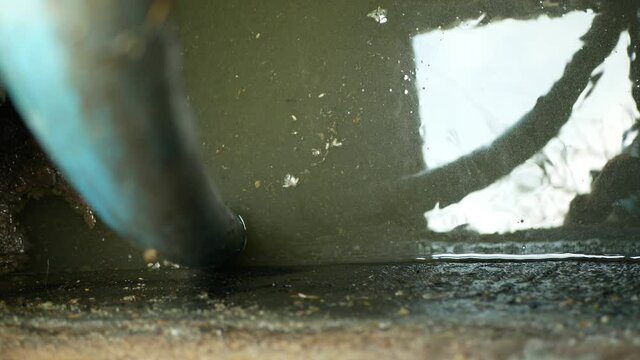 Cesspool pipe septic emptying pumping into tank by suction hose under high pressure. The sump contains pollution sludge sewage water black wastewater and faeces plus excrements from home