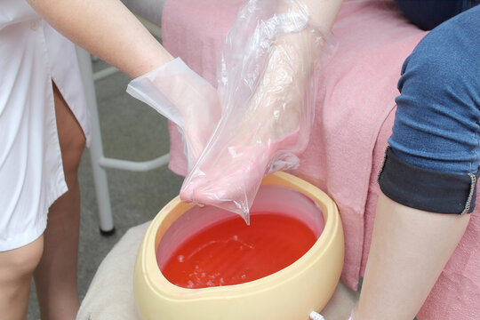 woman foot treatment in paraffin bath at the spa.