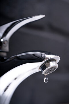 water drop dripping from the tap and water shortage	